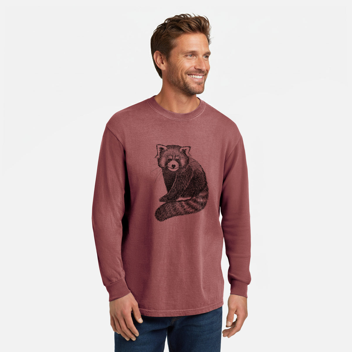 Brick red Comfort Colors long sleeve shirt printed with a detailed black ink illustration of a red panda sitting with its striped tail wrapped around, shown in a lifestyle photo.