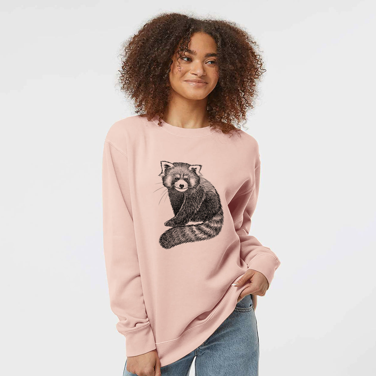 Model wearing a dusty pink pigment dyed crewneck sweatshirt printed with a detailed black ink illustration of a red panda sitting with its striped tail wrapped around.