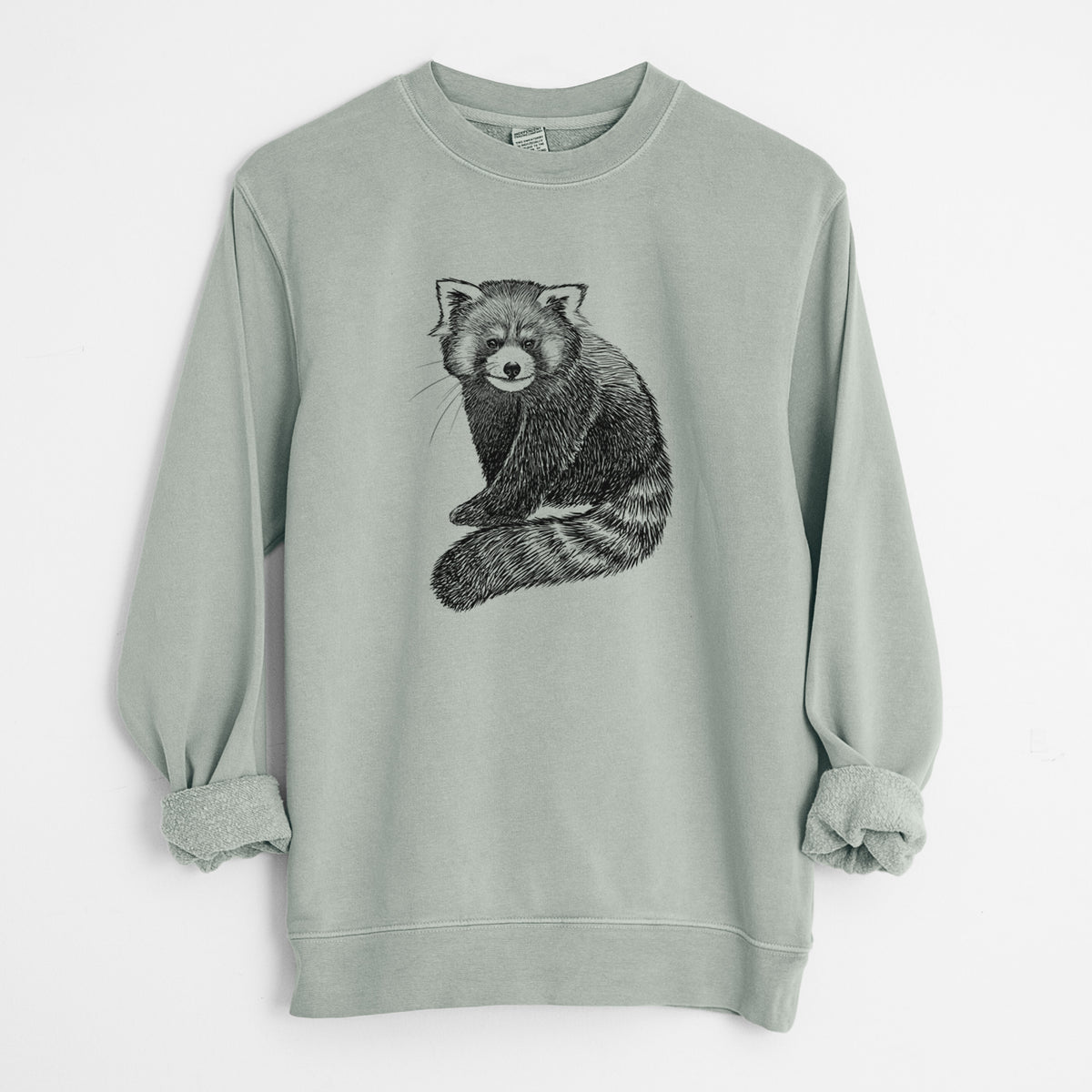 Sage green pigment dyed crewneck sweatshirt laid flat with the sleeves rolled, printed with a detailed black ink illustration of a red panda sitting with its striped tail wrapped around.