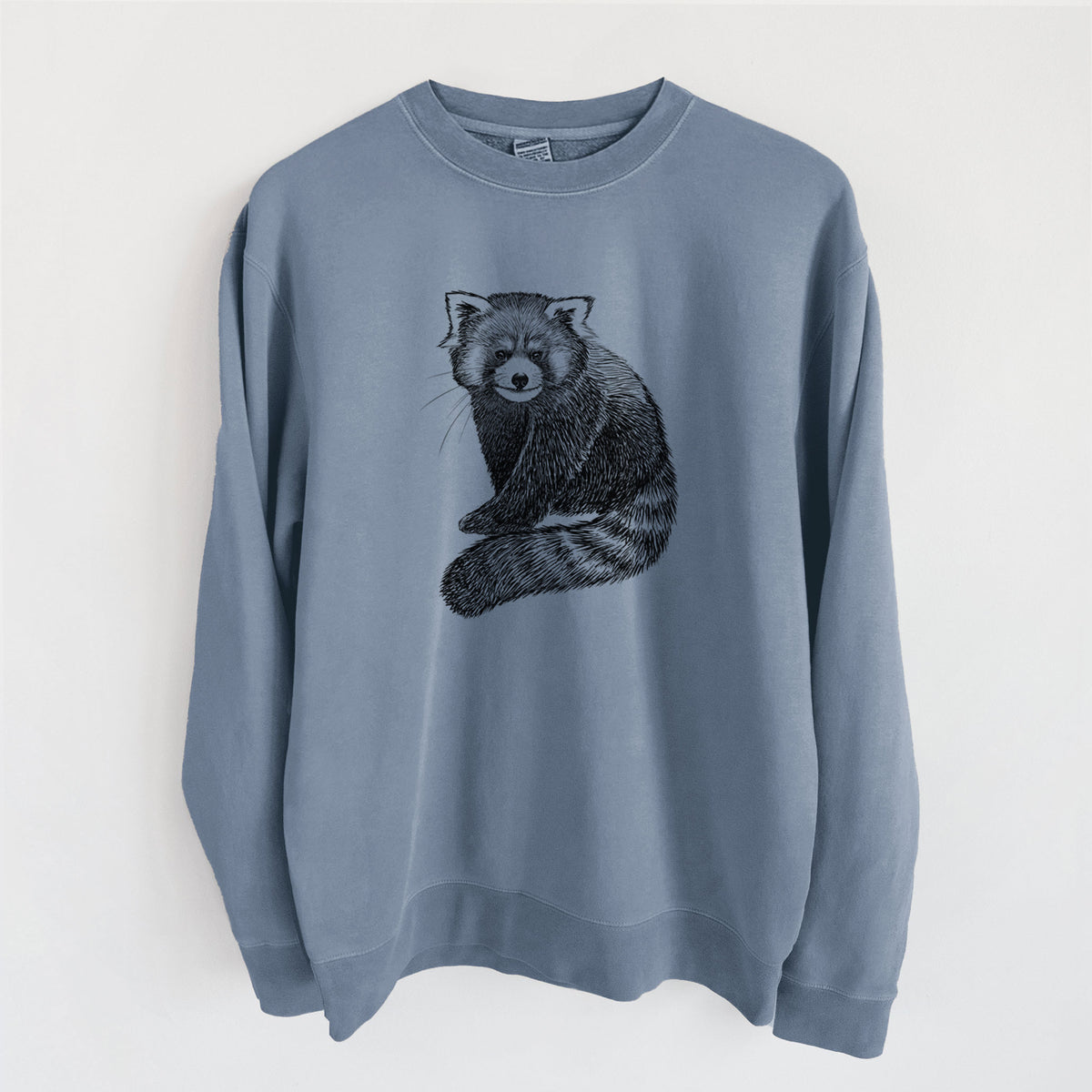 Slate blue pigment dyed crewneck sweatshirt laid flat, printed with a detailed black ink illustration of a red panda sitting with its striped tail wrapped around.