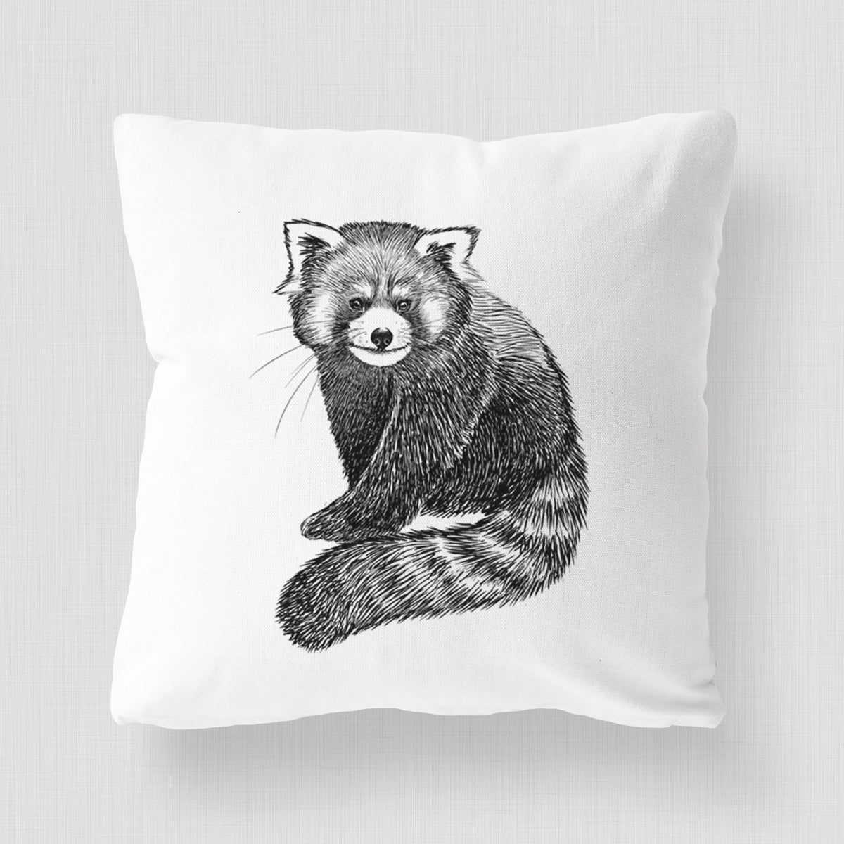 White pillow cover printed with a detailed black ink illustration of a red panda sitting with its striped tail wrapped around.