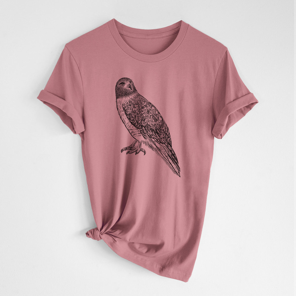 Mauve pink lightweight cotton t-shirt laid flat with the sleeves rolled, printed with a detailed black ink illustration of a red-tailed hawk perched.