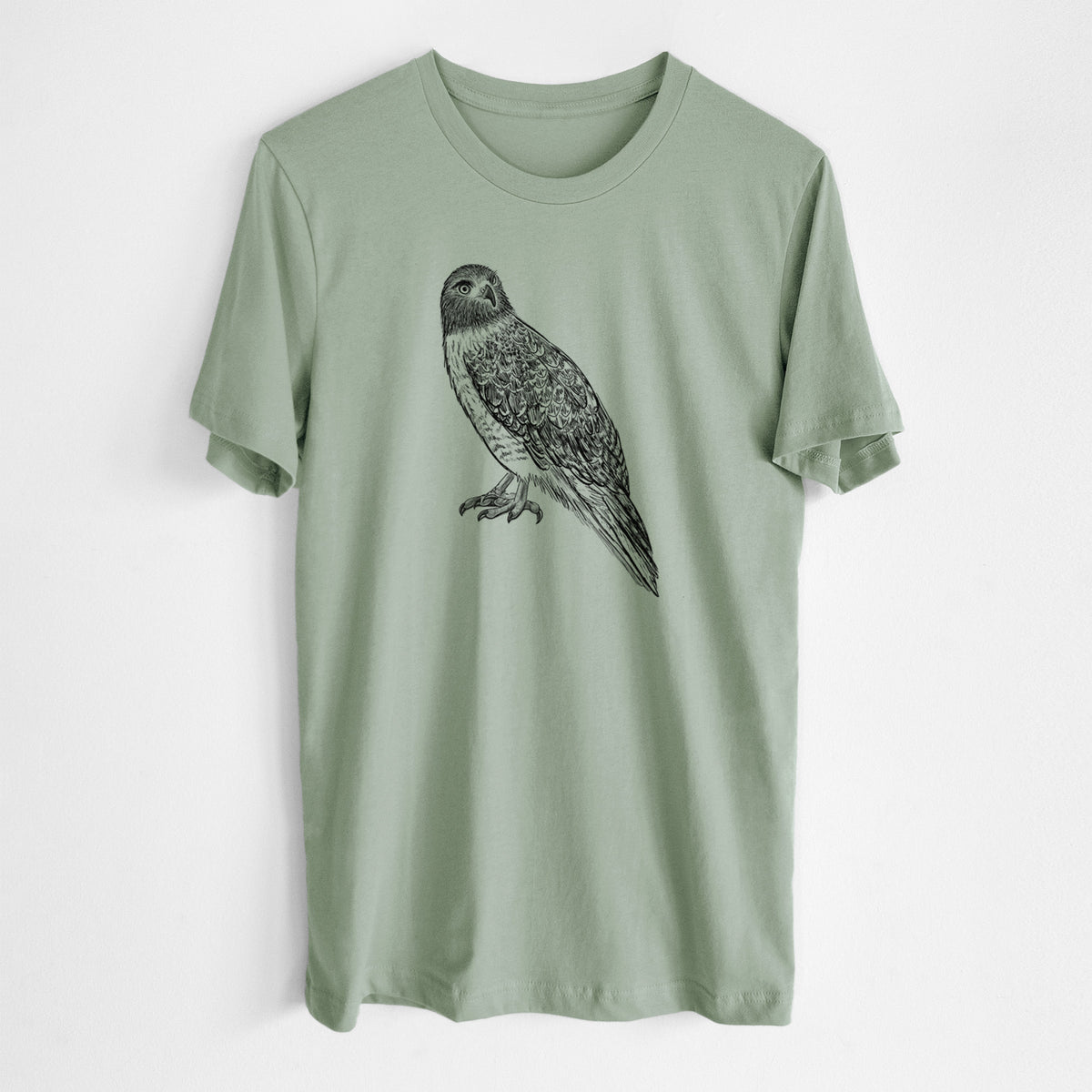 Sage green lightweight cotton t-shirt laid flat, printed with a detailed black ink illustration of a red-tailed hawk perched.