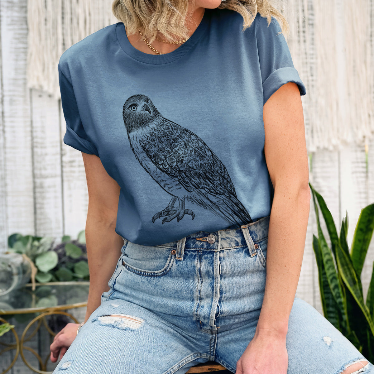 Woman wearing a steel blue lightweight cotton t-shirt printed with a detailed black ink illustration of a red-tailed hawk perched.
