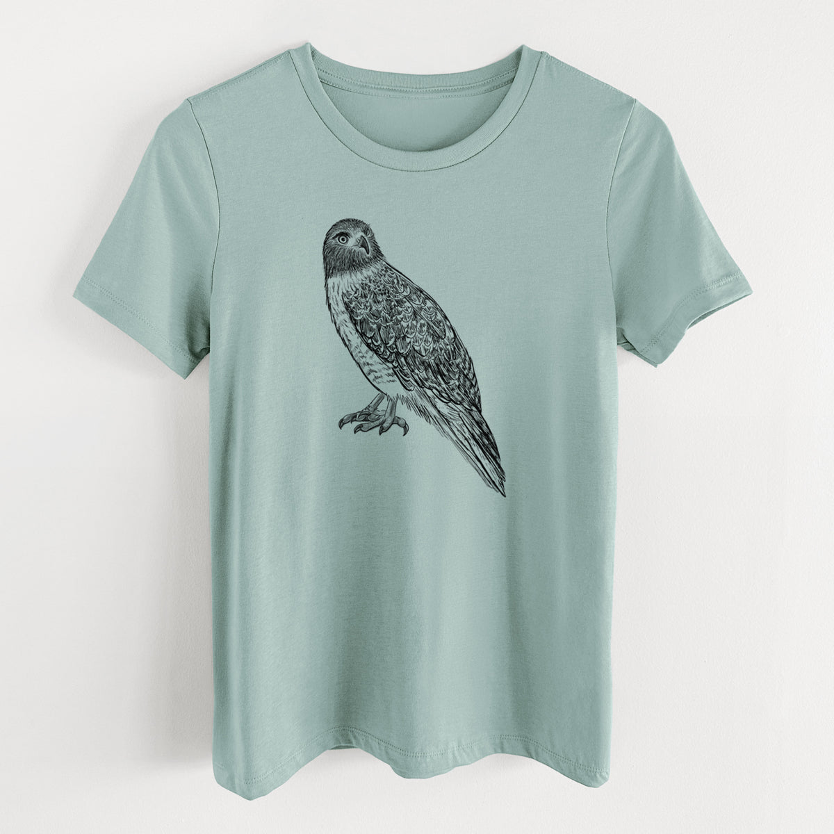 Dusty blue women's relaxed fit cotton t-shirt laid flat, printed with a detailed black ink illustration of a red-tailed hawk perched.