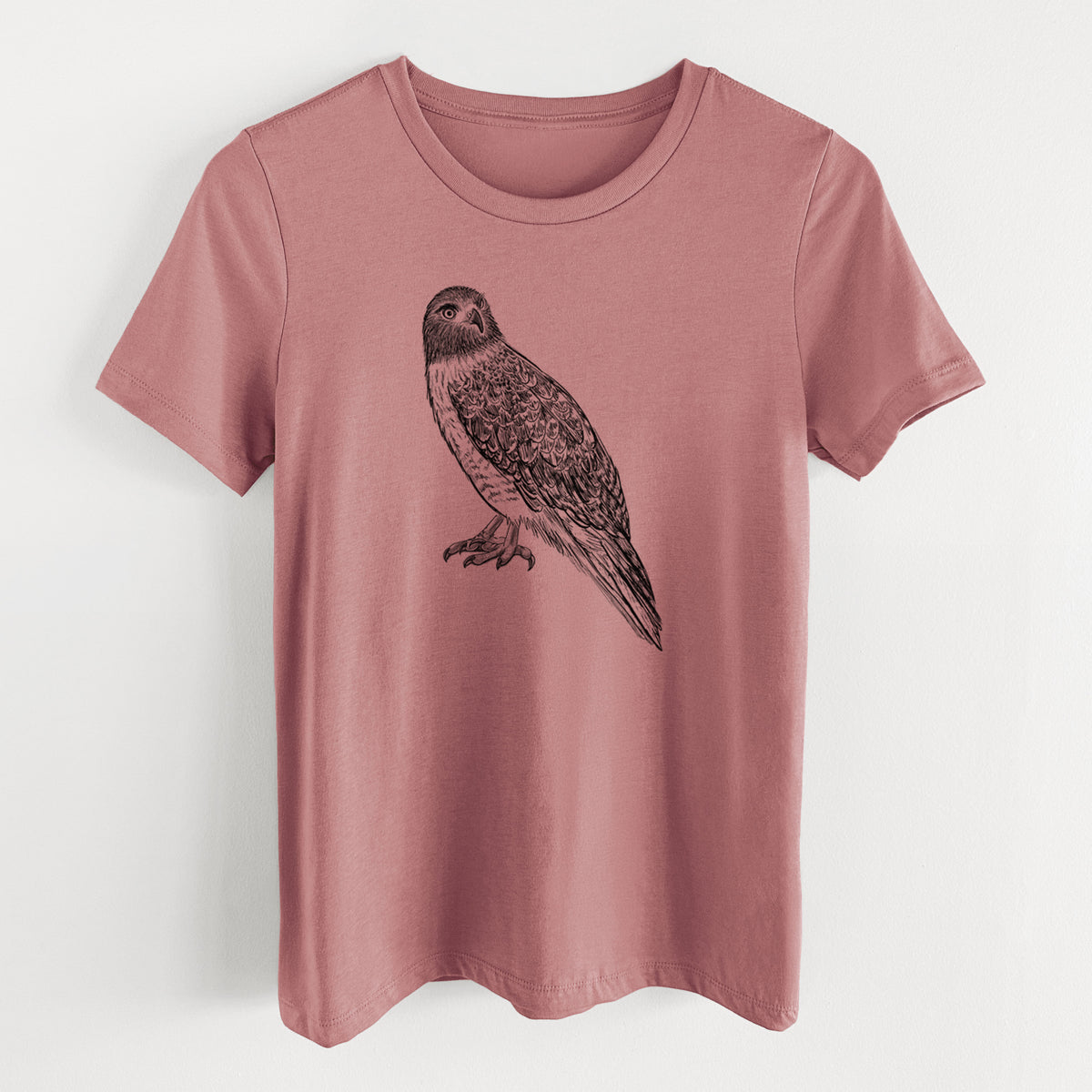 Mauve pink women's relaxed fit cotton t-shirt laid flat, printed with a detailed black ink illustration of a red-tailed hawk perched.