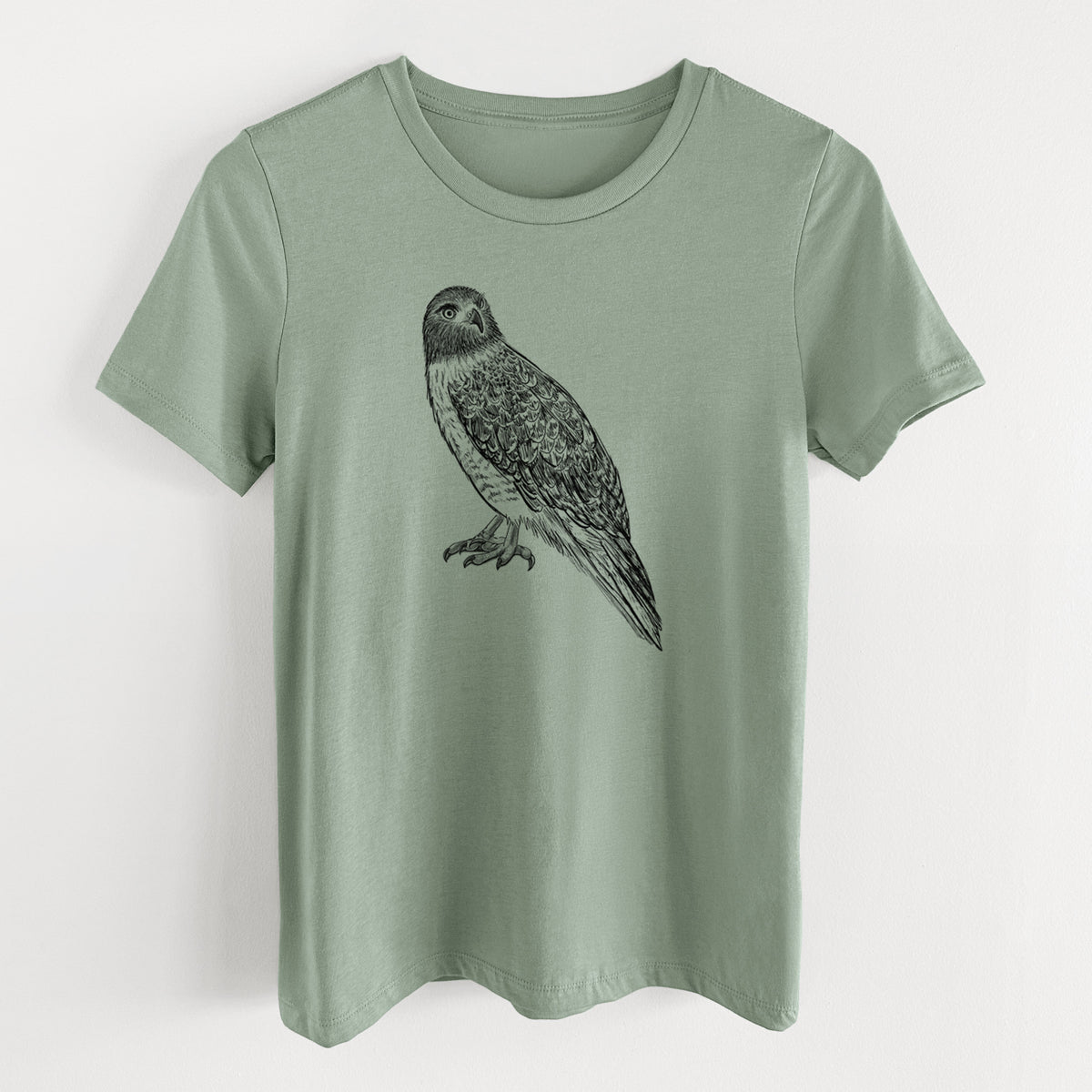 Sage green women's relaxed fit cotton t-shirt laid flat, printed with a detailed black ink illustration of a red-tailed hawk perched.