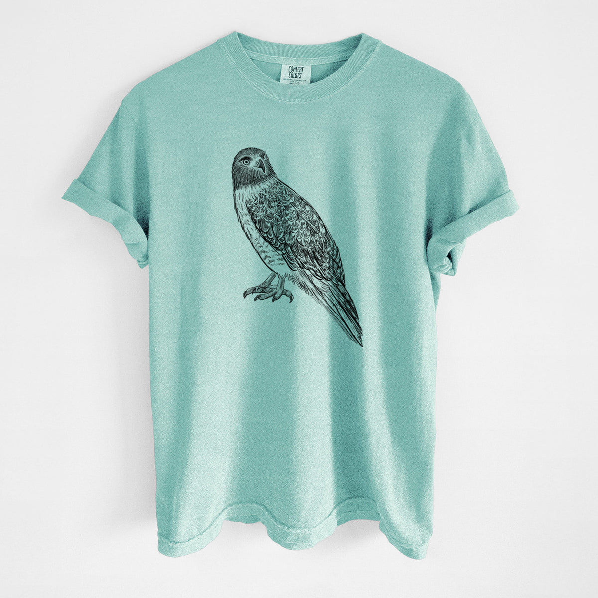 Chalky mint Comfort Colors t-shirt laid flat, printed with a detailed black ink illustration of a red-tailed hawk perched.