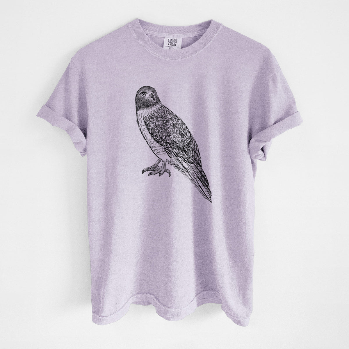 Orchid purple Comfort Colors t-shirt laid flat, printed with a detailed black ink illustration of a red-tailed hawk perched.