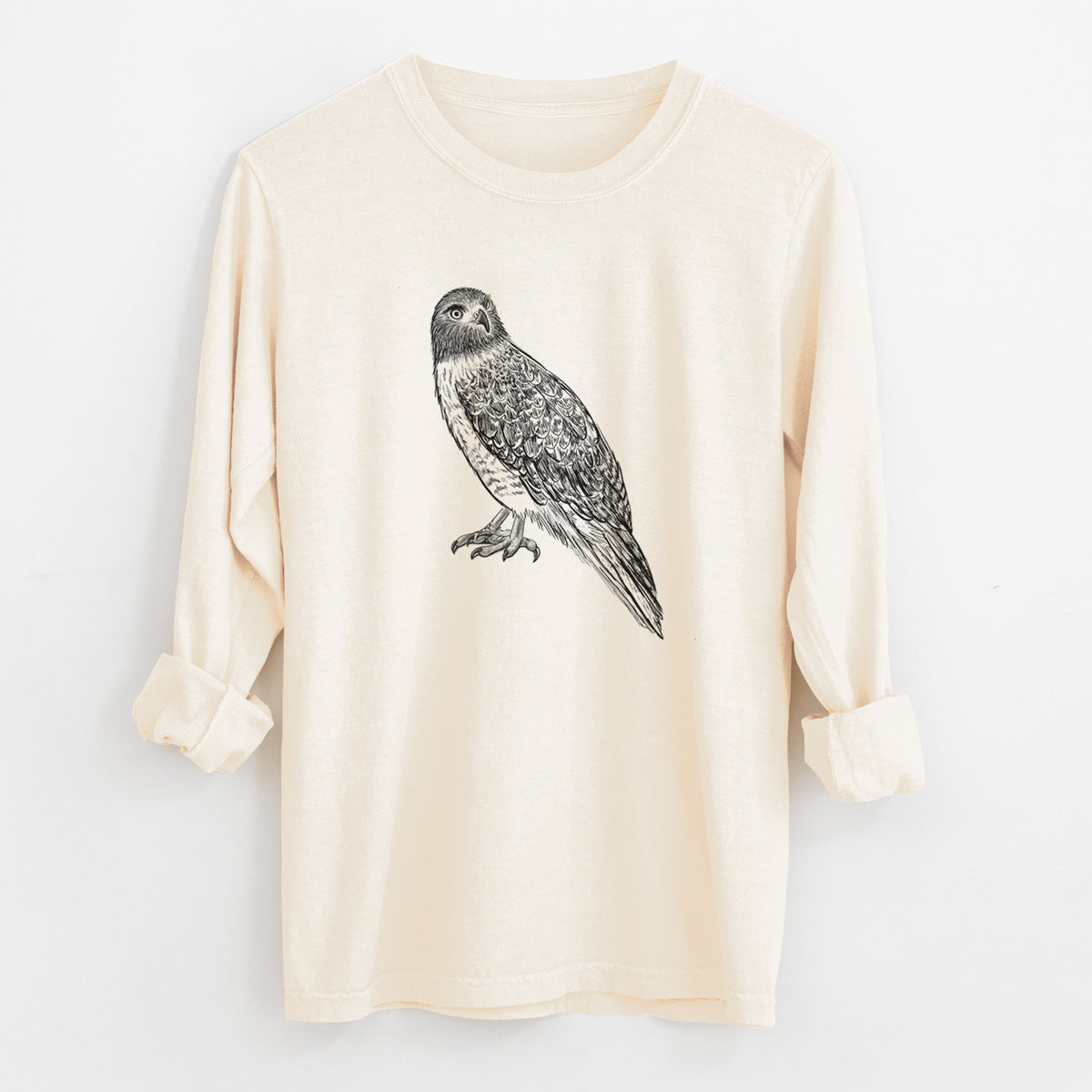 Ivory Comfort Colors long sleeve shirt laid flat with the cuffs rolled, printed with a detailed black ink illustration of a red-tailed hawk perched.