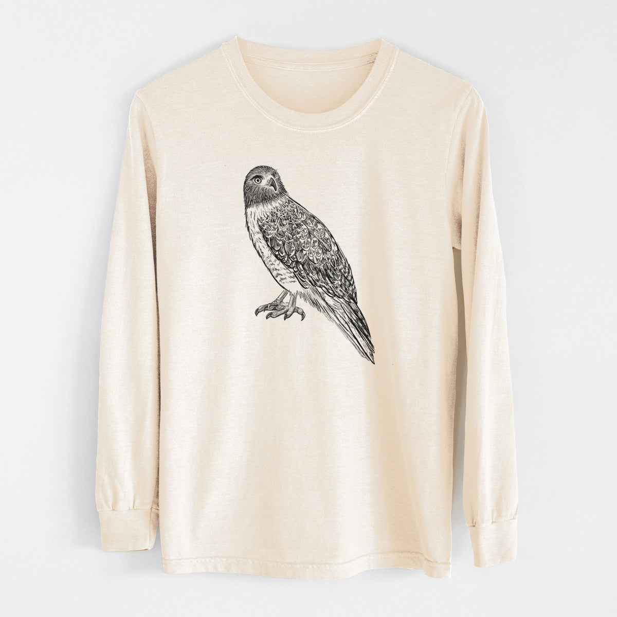 Ivory Comfort Colors long sleeve shirt laid flat, printed with a detailed black ink illustration of a red-tailed hawk perched.