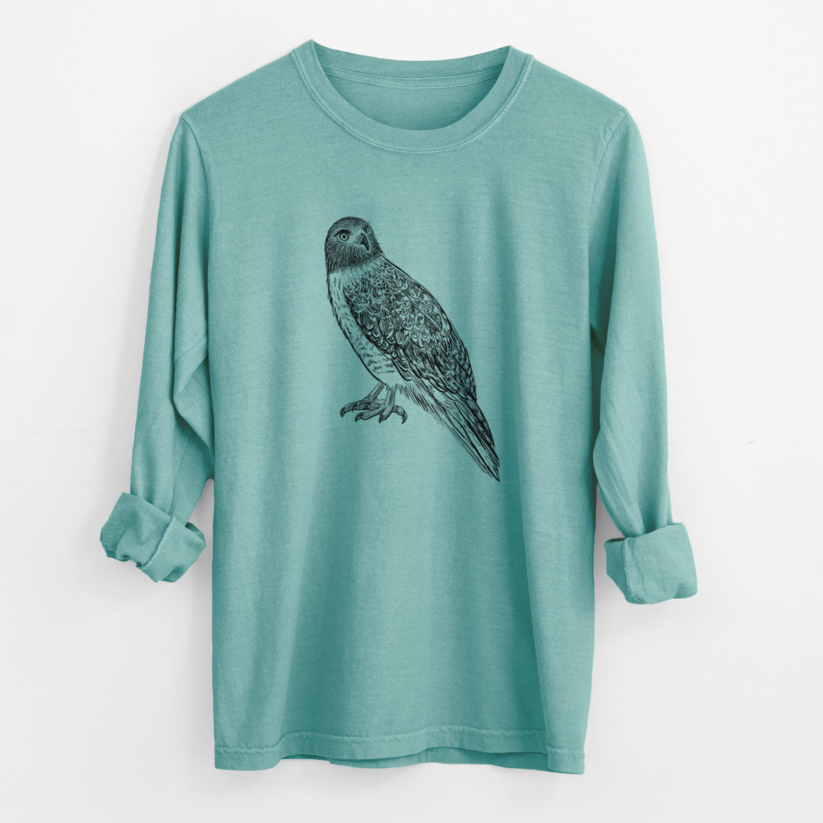 Reef green Comfort Colors long sleeve shirt laid flat with the cuffs rolled, printed with a detailed black ink illustration of a red-tailed hawk perched.