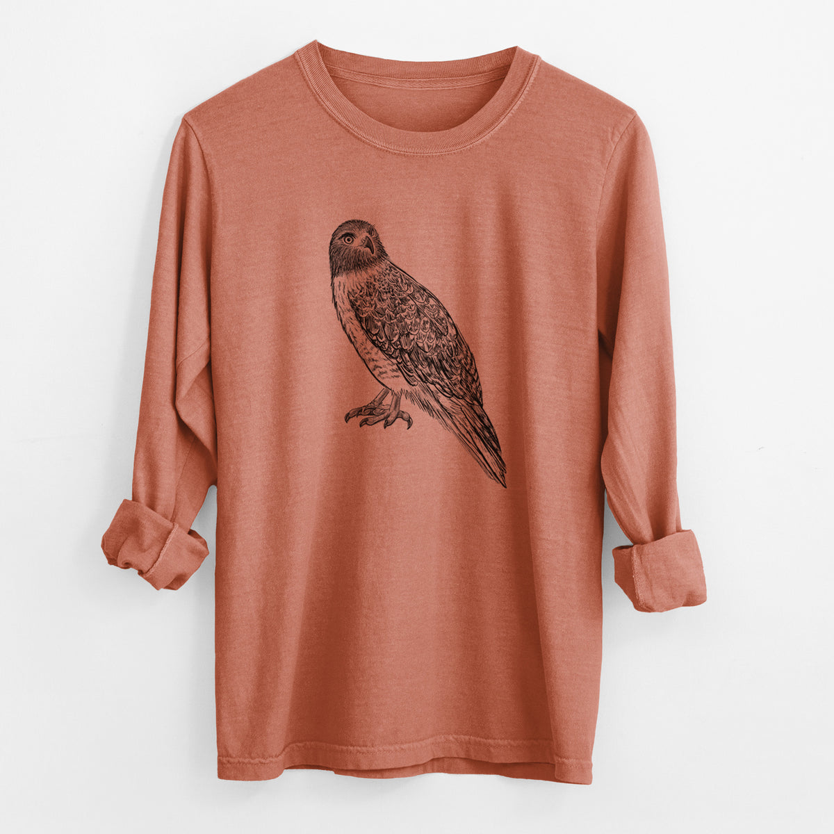 Yam burnt orange Comfort Colors long sleeve shirt laid flat with the cuffs rolled, printed with a detailed black ink illustration of a red-tailed hawk perched.