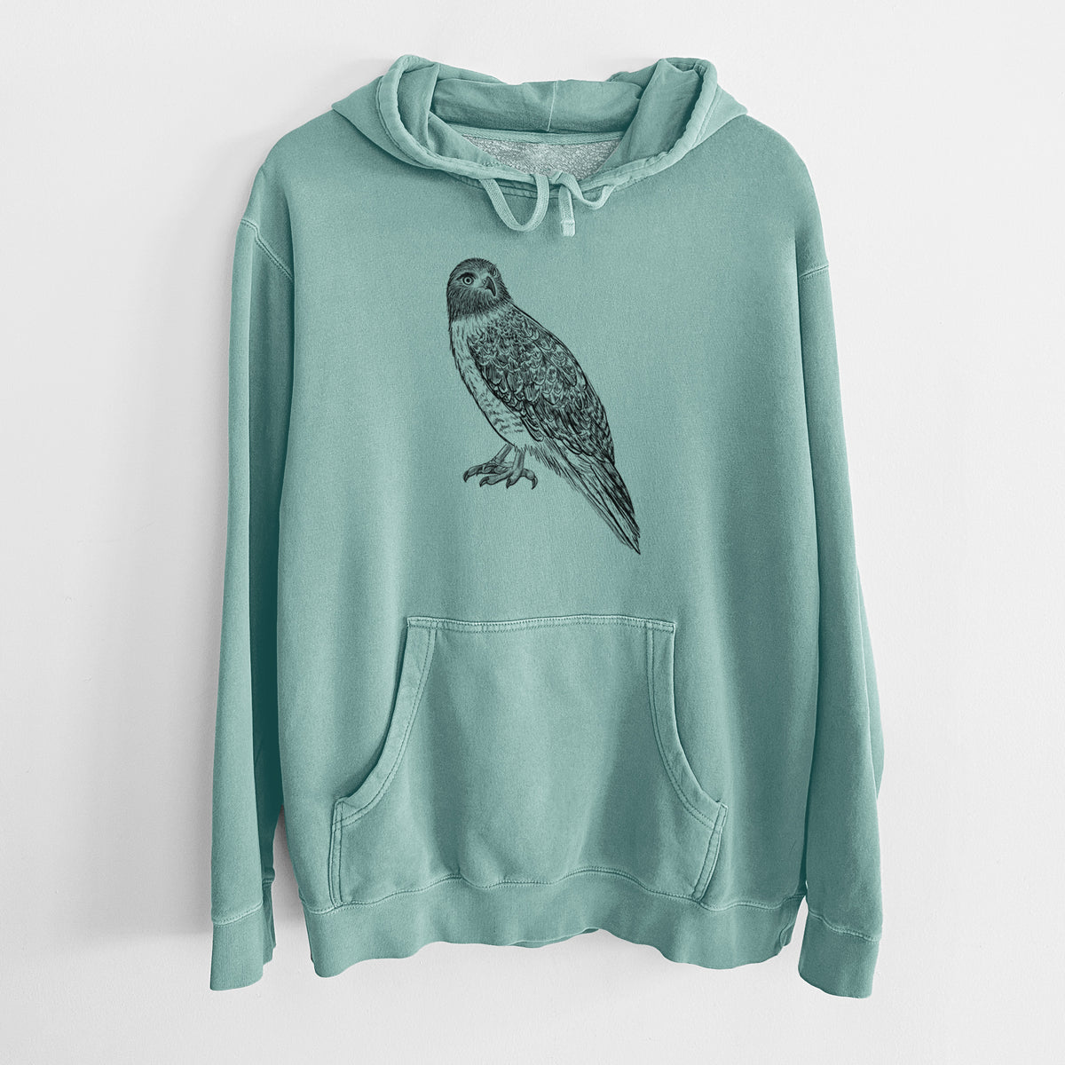 Mint green pigment dyed hoodie laid flat, printed with a detailed black ink illustration of a red-tailed hawk perched.