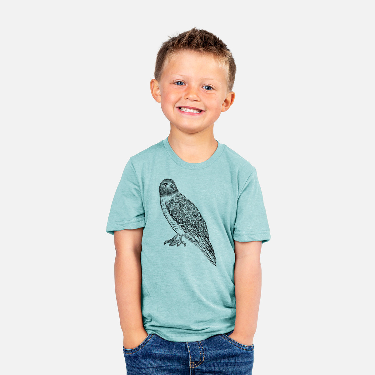Smiling boy wearing a youth t-shirt printed with a detailed black ink illustration of a red-tailed hawk perched.
