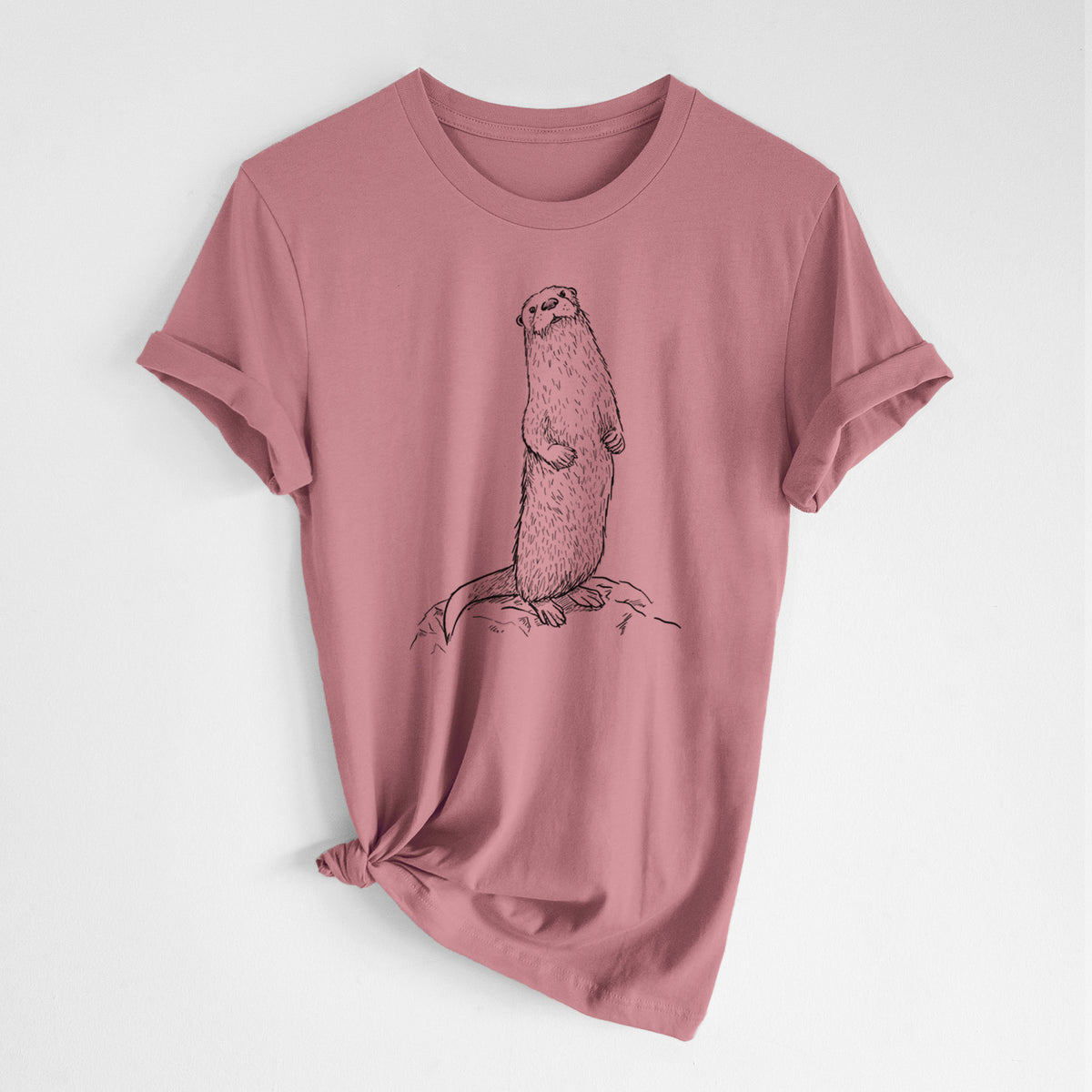 Mauve pink lightweight cotton t-shirt laid flat with the sleeves rolled, printed with a black ink illustration of a river otter standing upright on a rock.