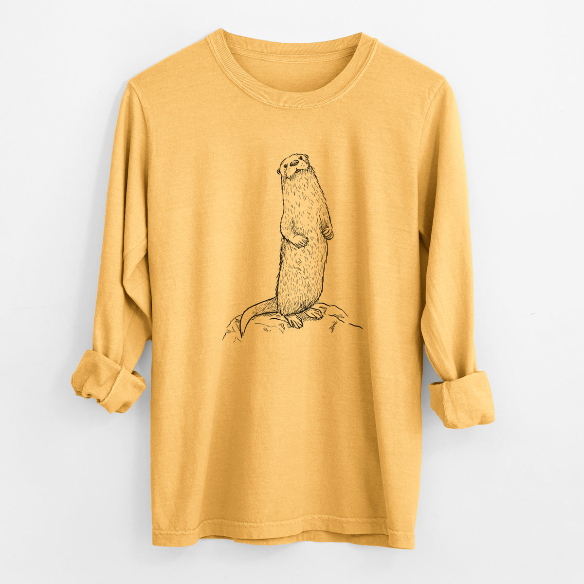 Golden wheat yellow Comfort Colors long sleeve shirt laid flat with the cuffs rolled, printed with a black ink illustration of a river otter standing upright on a rock.