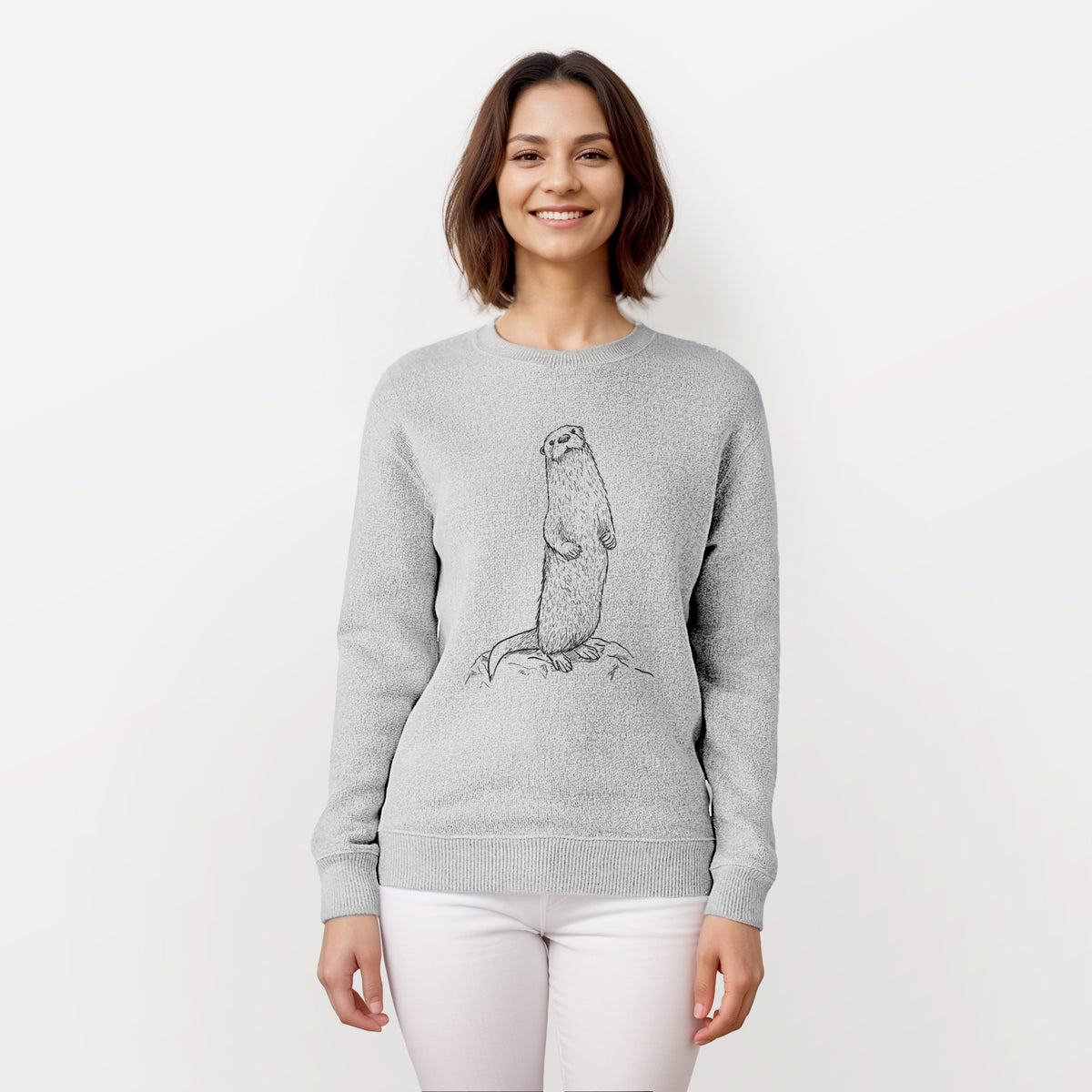 Woman wearing a knit sweatshirt printed with a black ink illustration of a river otter standing upright on a rock.