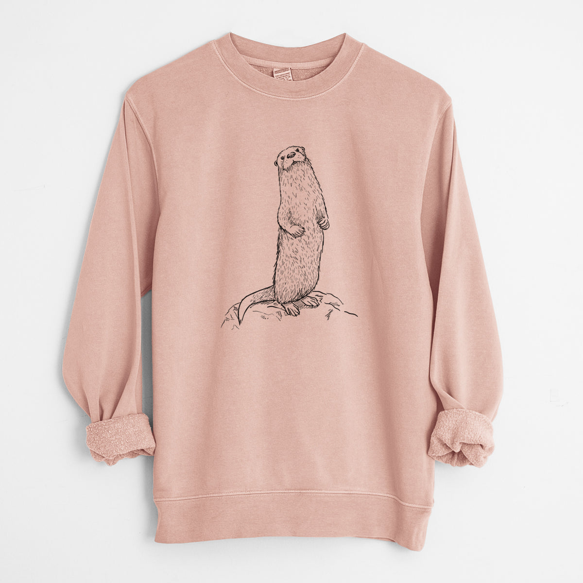 Dusty pink pigment dyed crewneck sweatshirt laid flat with the sleeves rolled, printed with a black ink illustration of a river otter standing upright on a rock.