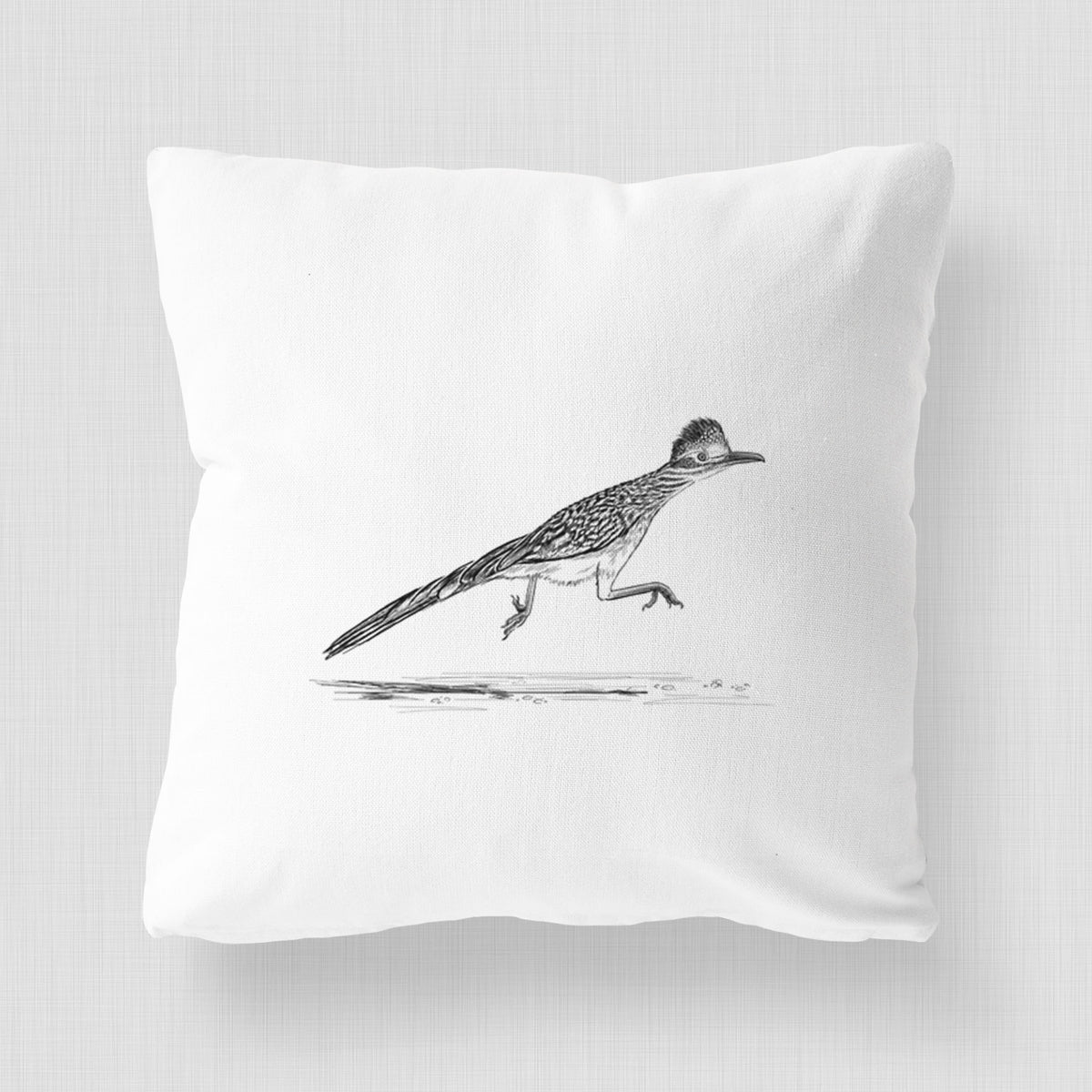 White pillow cover printed with a black ink illustration of a roadrunner running.