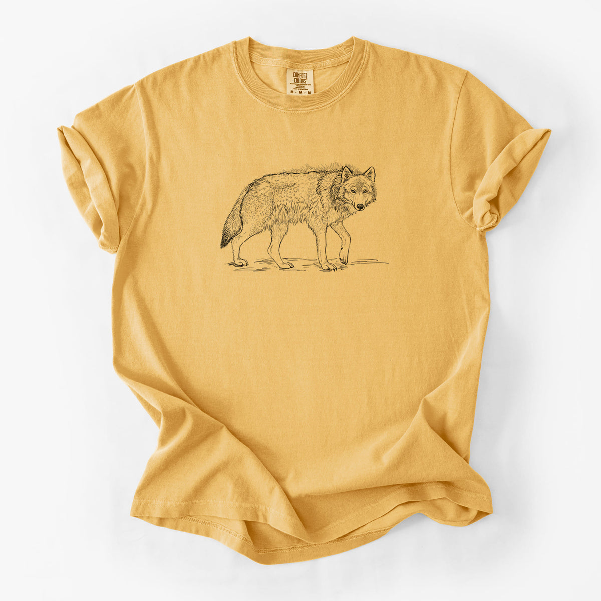 Golden wheat yellow Comfort Colors t-shirt laid flat, printed with a detailed black ink illustration of a grey wolf walking.