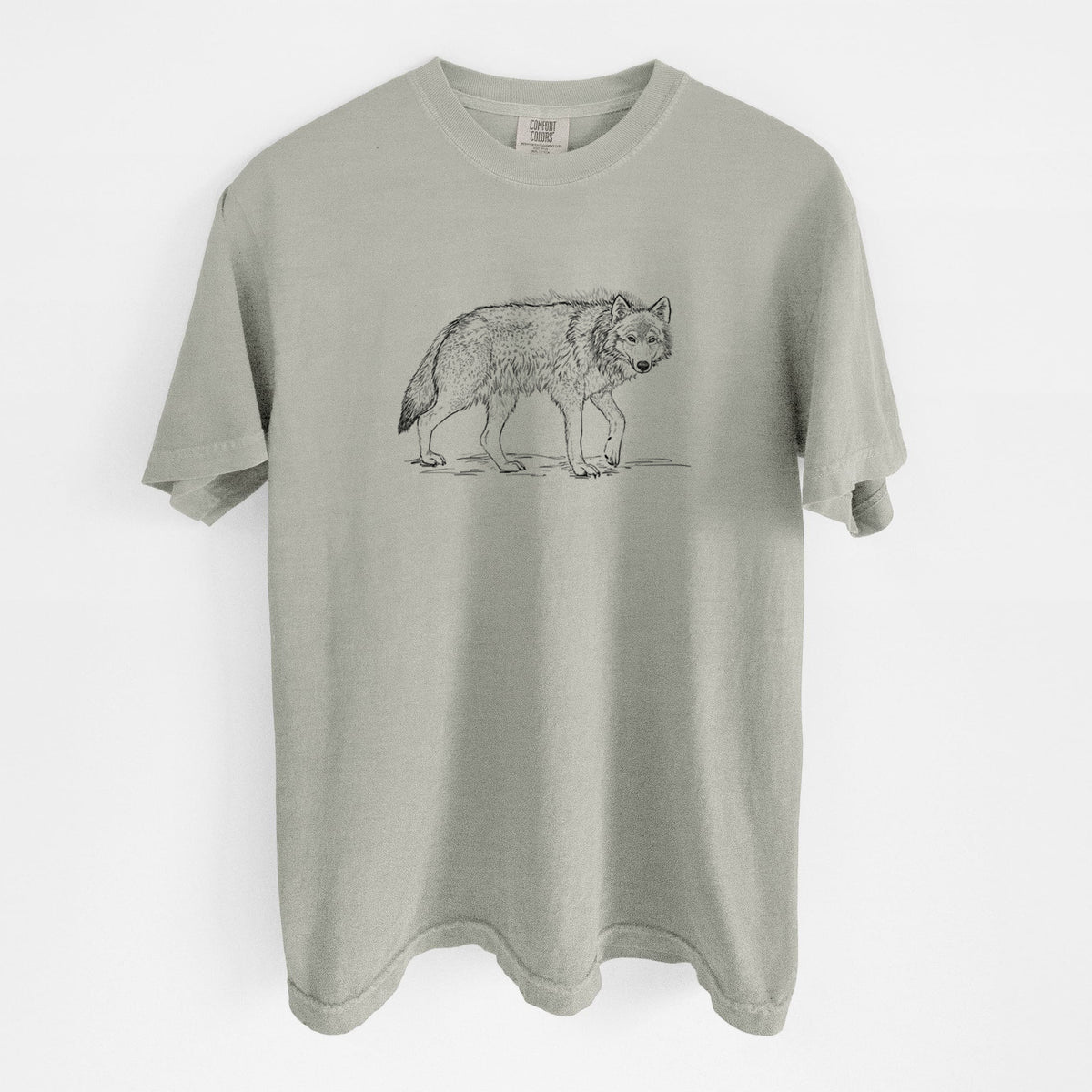 Sandstone beige Comfort Colors t-shirt laid flat, printed with a detailed black ink illustration of a grey wolf walking.