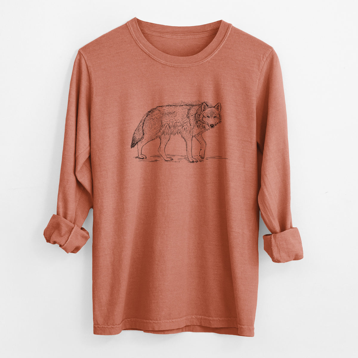 Yam burnt orange Comfort Colors long sleeve shirt laid flat with the cuffs rolled, printed with a detailed black ink illustration of a grey wolf walking.