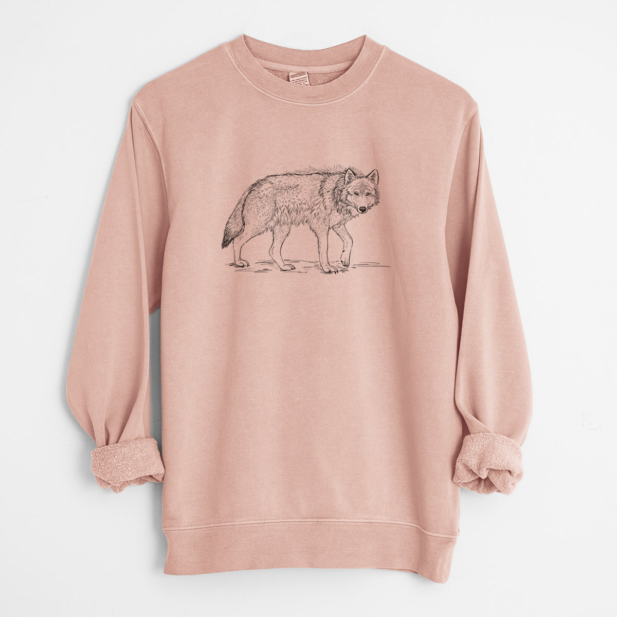 Dusty pink pigment dyed crewneck sweatshirt laid flat with the sleeves rolled, printed with a detailed black ink illustration of a grey wolf walking.