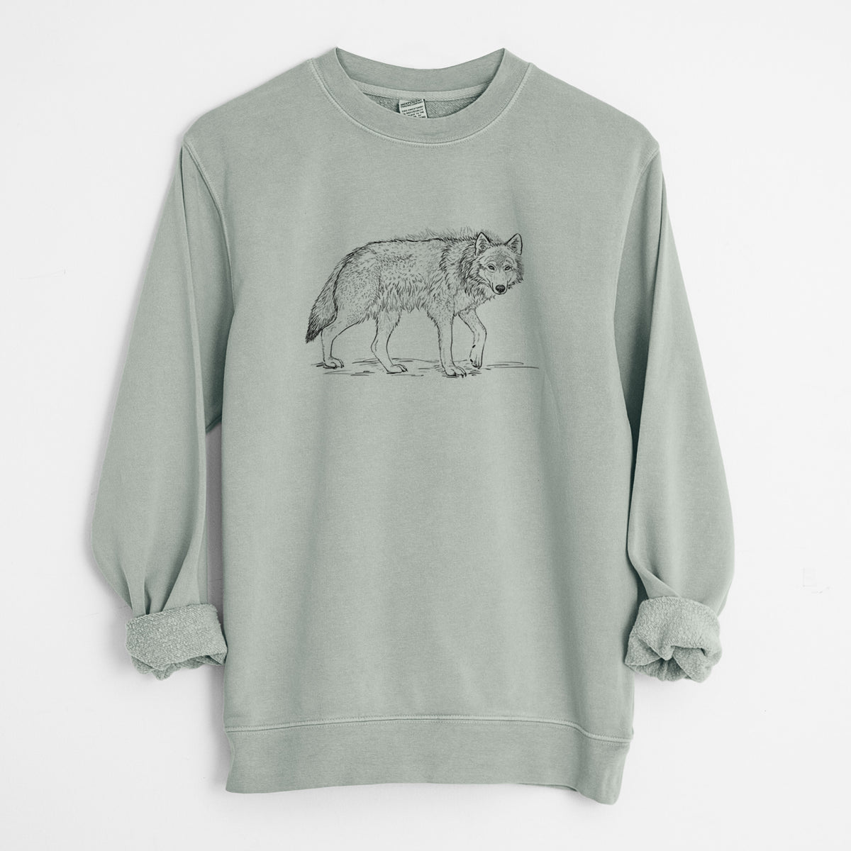 Sage green pigment dyed crewneck sweatshirt laid flat with the sleeves rolled, printed with a detailed black ink illustration of a grey wolf walking.