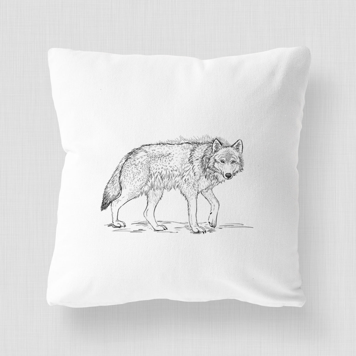 White pillow cover printed with a detailed black ink illustration of a grey wolf walking.