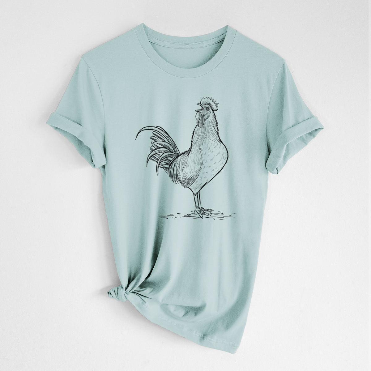 Dusty blue lightweight cotton t-shirt laid flat with the sleeves rolled, printed with a detailed black ink illustration of a rooster crowing.