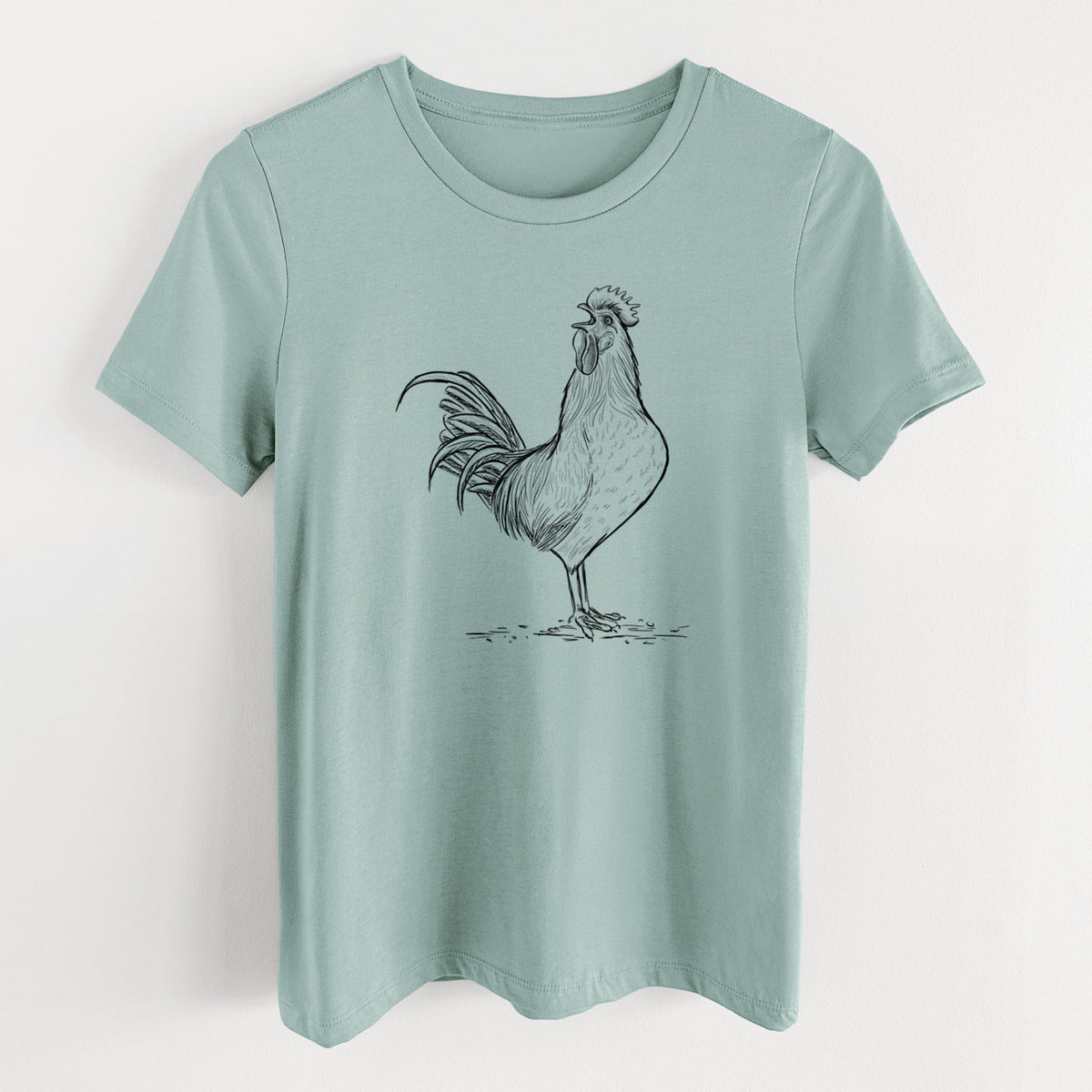 Dusty blue women's relaxed fit cotton t-shirt laid flat, printed with a detailed black ink illustration of a rooster crowing.
