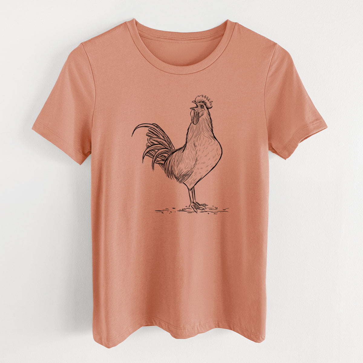 Terracotta orange women's relaxed fit cotton t-shirt laid flat, printed with a detailed black ink illustration of a rooster crowing.