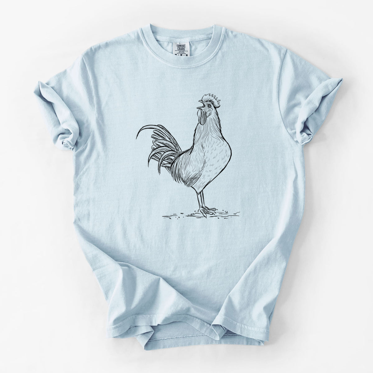Chambray blue Comfort Colors t-shirt laid flat, printed with a detailed black ink illustration of a rooster crowing.