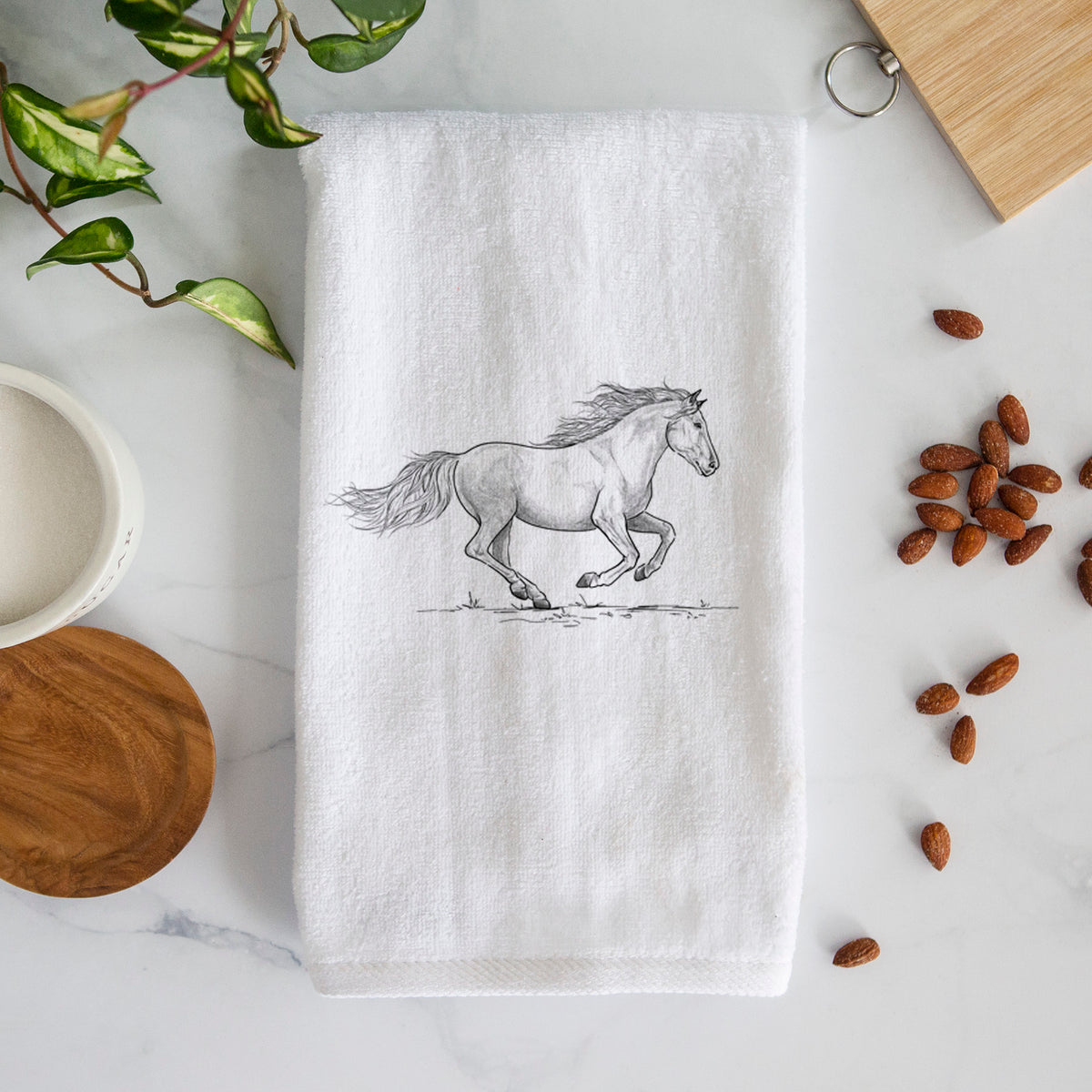 White hand towel printed with a black ink illustration of a mustang horse running.