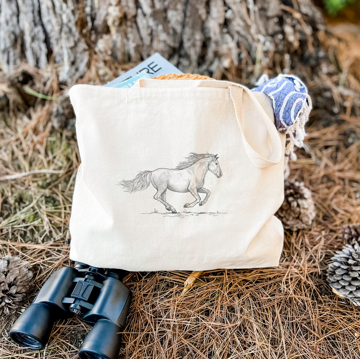 Canvas tote bag printed with a black ink illustration of a mustang horse running, resting on dry grass beside a pair of binoculars.