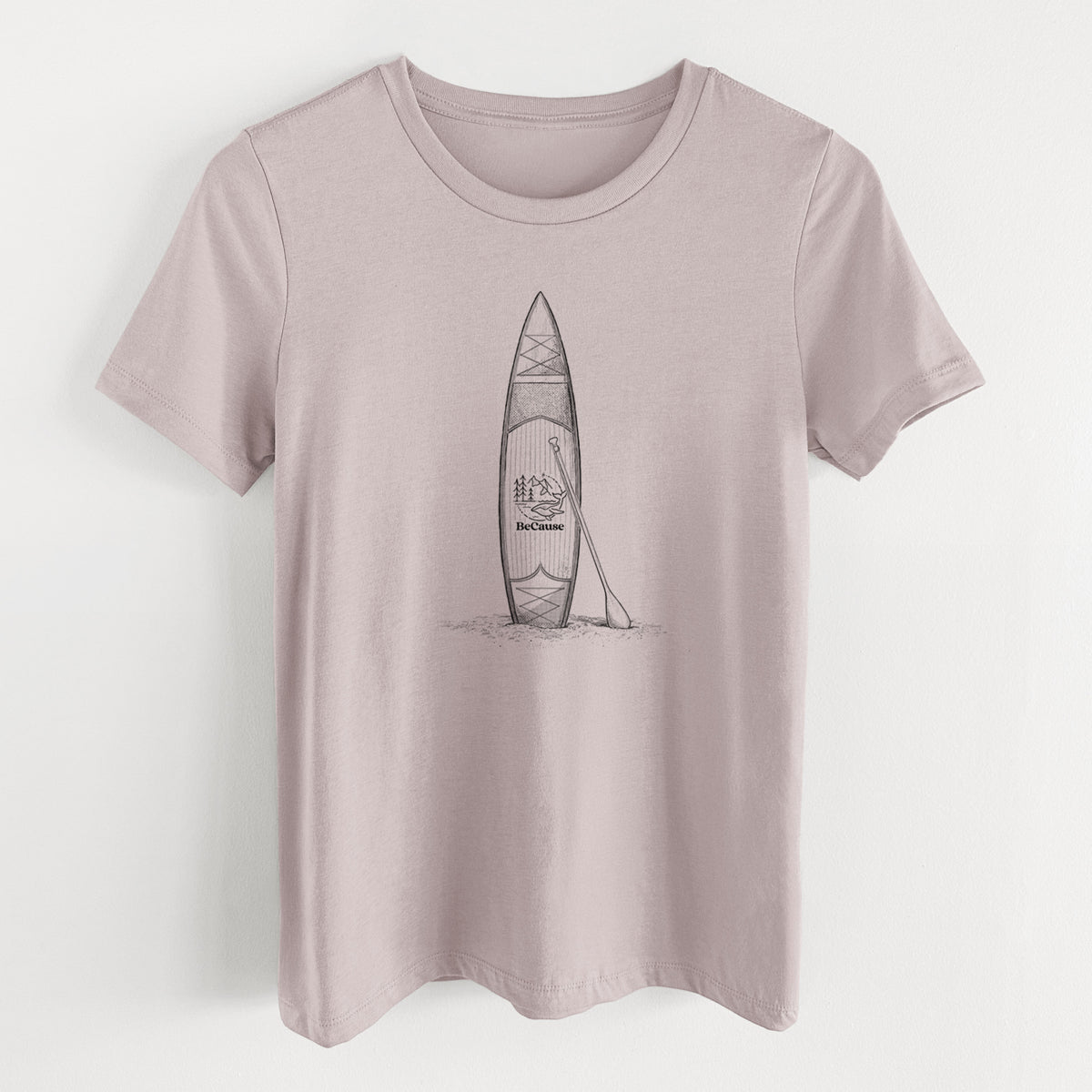 Pink gravel women's relaxed fit cotton t-shirt laid flat, printed with a black ink illustration of a stand-up paddleboard with a paddle.