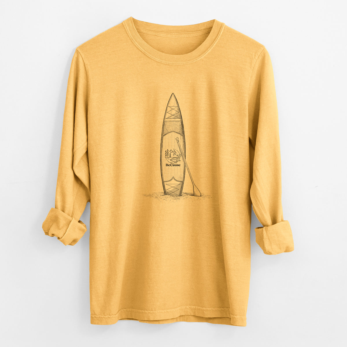 Golden wheat yellow Comfort Colors long sleeve shirt laid flat with the cuffs rolled, printed with a black ink illustration of a stand-up paddleboard with a paddle.