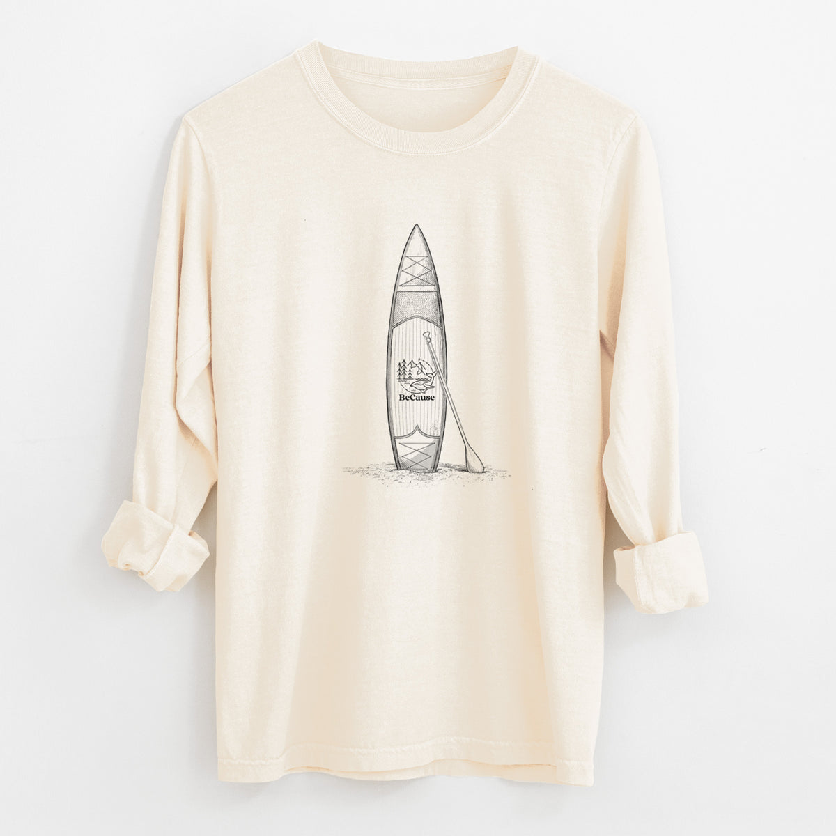 Ivory Comfort Colors long sleeve shirt laid flat with the cuffs rolled, printed with a black ink illustration of a stand-up paddleboard with a paddle.