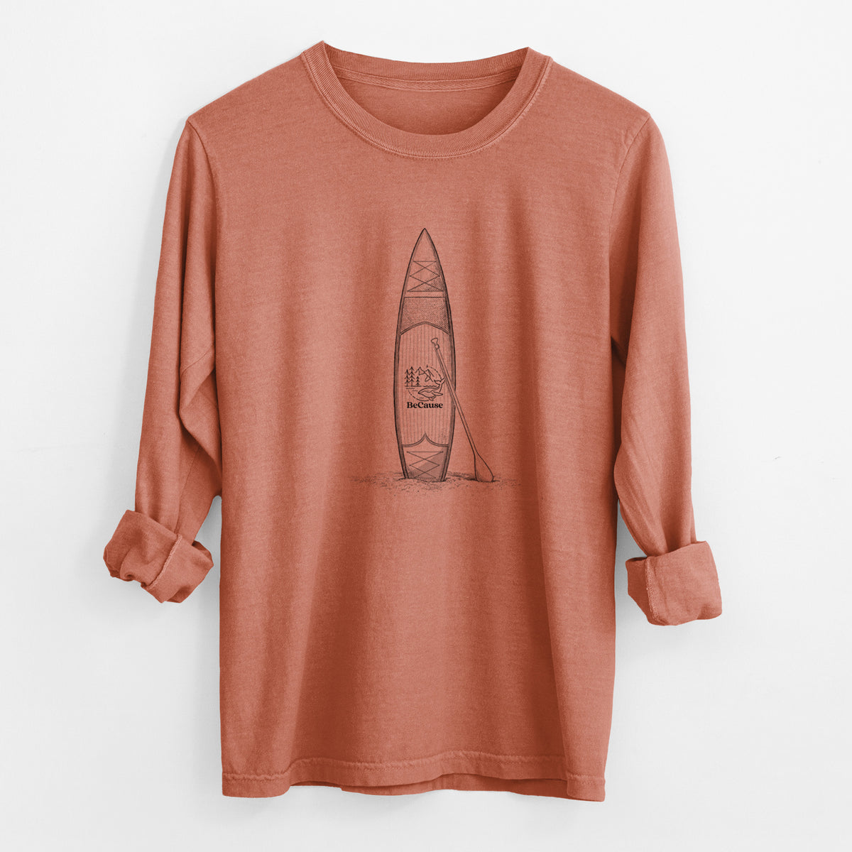 Yam burnt orange Comfort Colors long sleeve shirt laid flat with the cuffs rolled, printed with a black ink illustration of a stand-up paddleboard with a paddle.