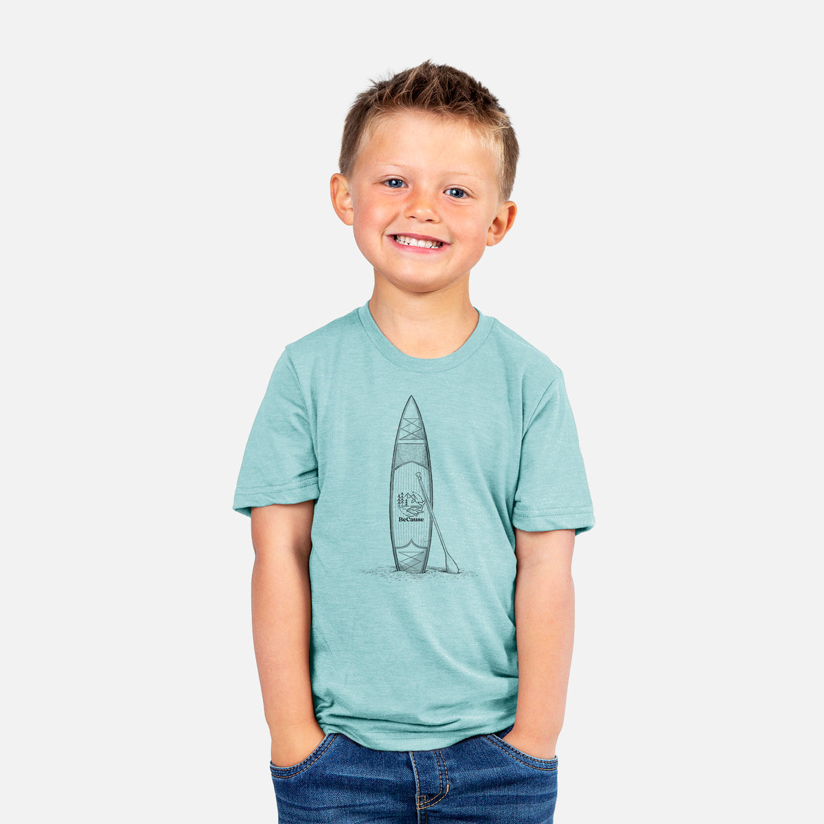 Smiling boy wearing a youth t-shirt printed with a black ink illustration of a stand-up paddleboard with a paddle.