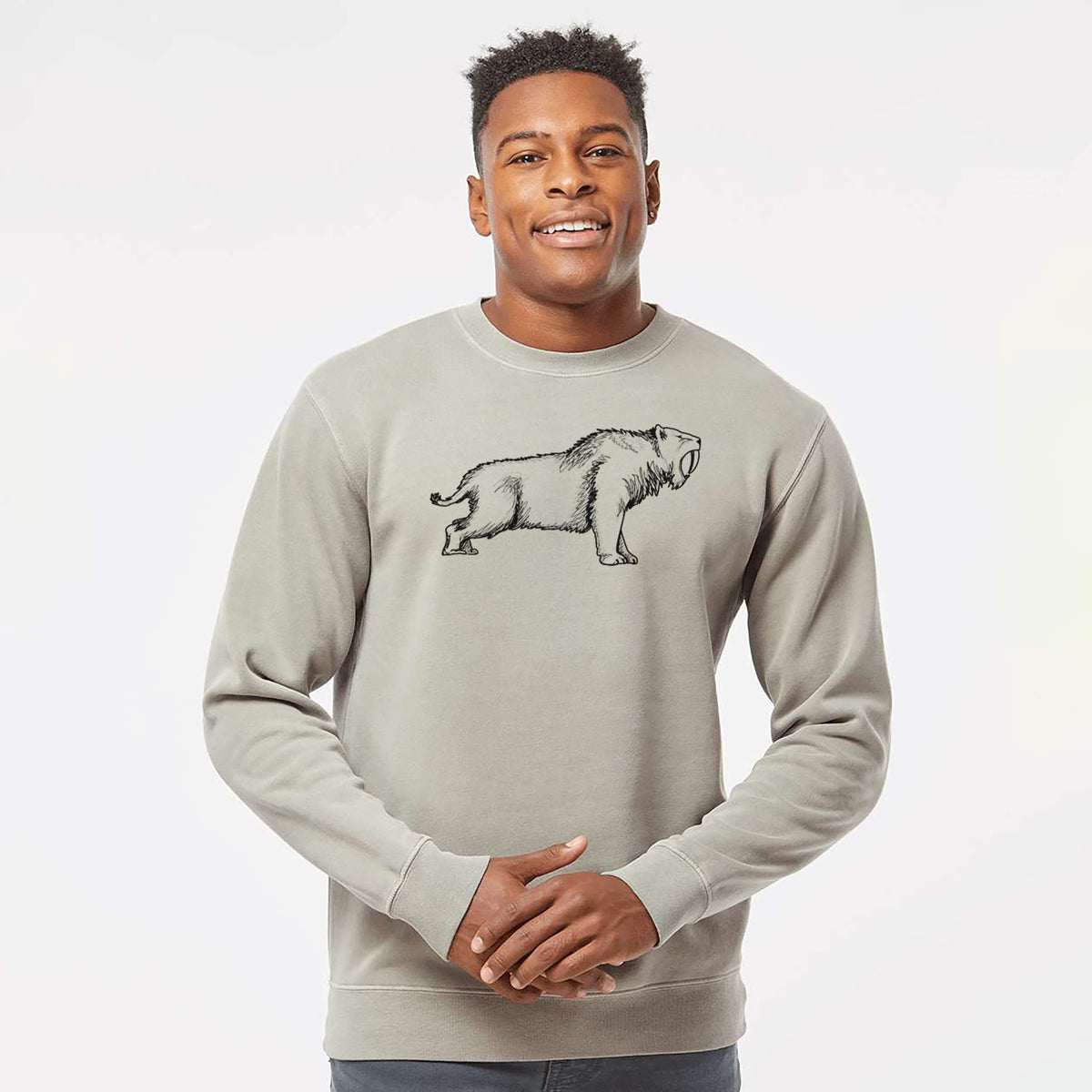 Model wearing a cement grey pigment dyed crewneck sweatshirt printed with a black ink illustration of a saber-toothed tiger walking.