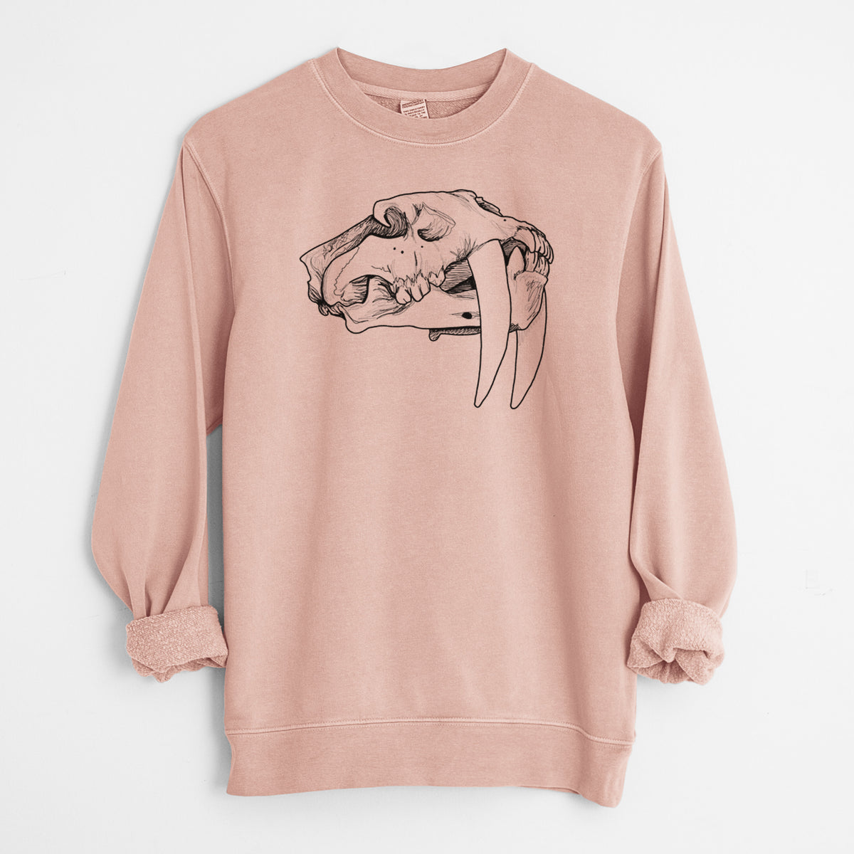 Dusty pink pigment dyed crewneck sweatshirt laid flat with the sleeves rolled, printed with a detailed black ink illustration of a saber-toothed tiger skull.
