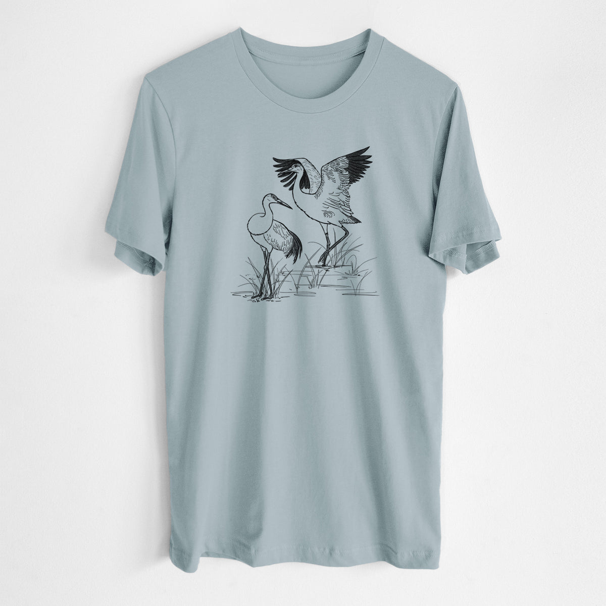 Vintage denim lightweight cotton t-shirt laid flat, printed with a black ink illustration of two sandhill cranes in marsh grass, one with its wings raised.