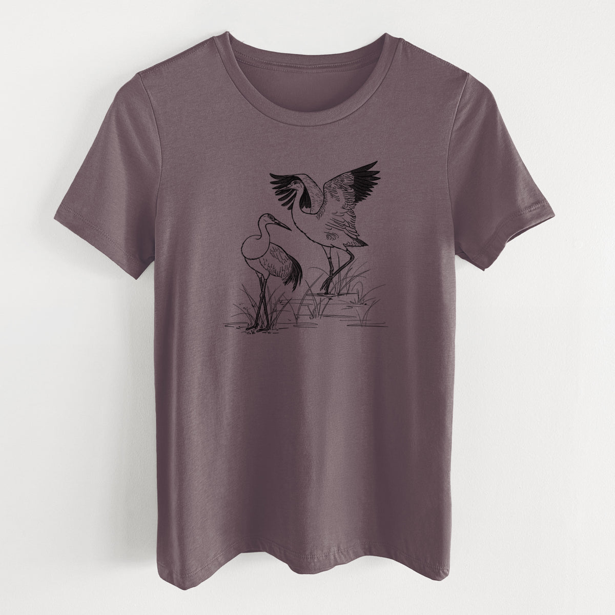 Purple storm women's relaxed fit cotton t-shirt laid flat, printed with a black ink illustration of two sandhill cranes in marsh grass, one with its wings raised.