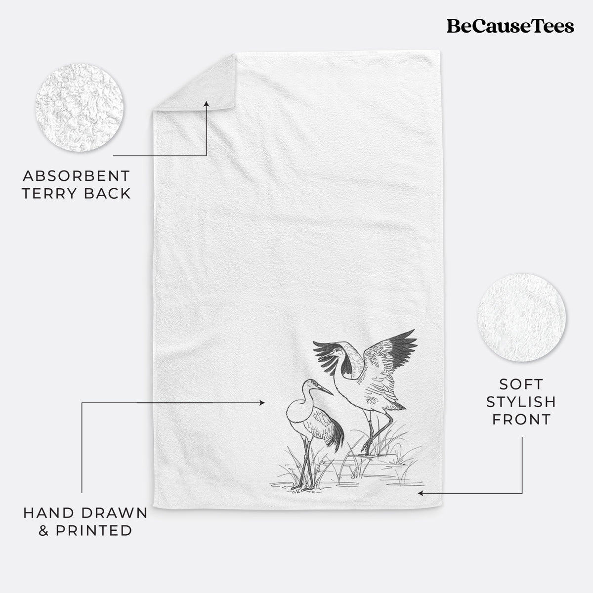 White hand towel printed with a black ink illustration of two sandhill cranes in marsh grass, one with its wings raised.