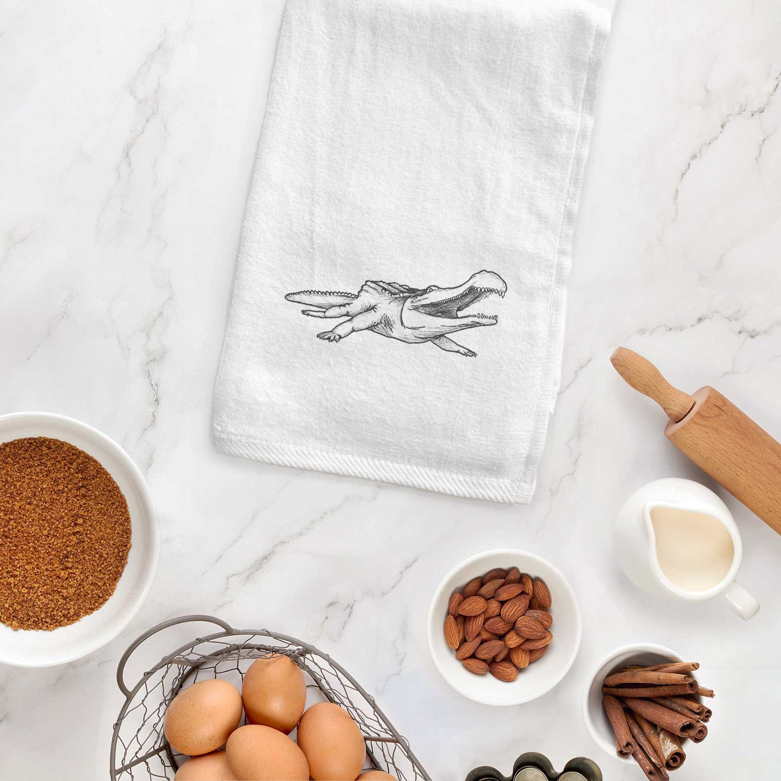 White hand towel printed with a black ink illustration of a Sarcosuchus, a giant prehistoric crocodile.
