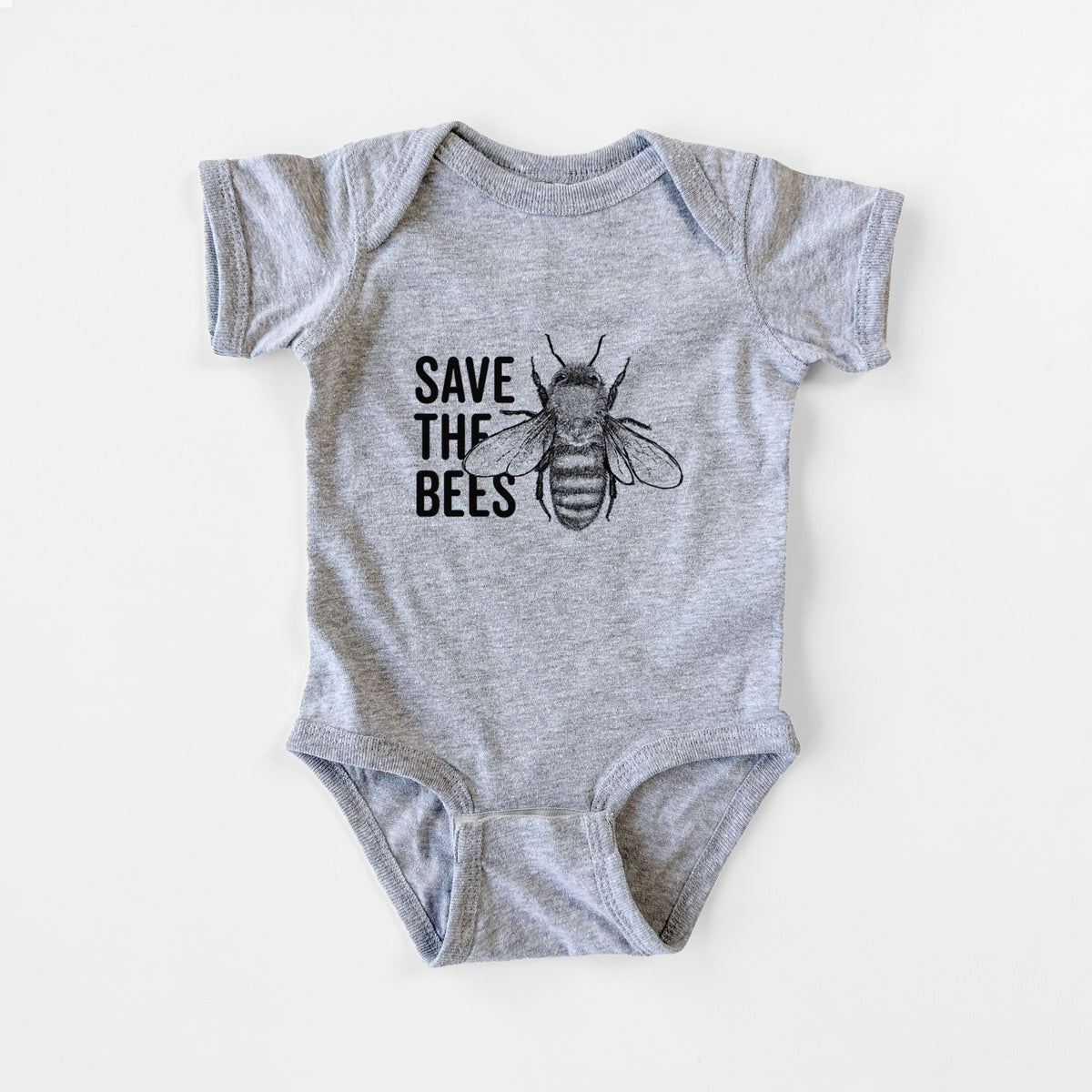Grey baby bodysuit laid flat, printed with bold black words reading Save the Bees beside a detailed honey bee illustration.