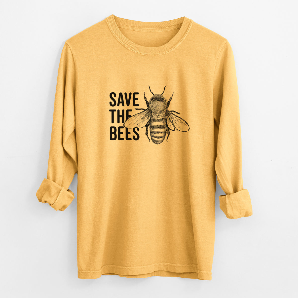 Golden wheat yellow Comfort Colors long sleeve shirt laid flat with the cuffs rolled, printed with bold black words reading Save the Bees beside a detailed honey bee illustration.
