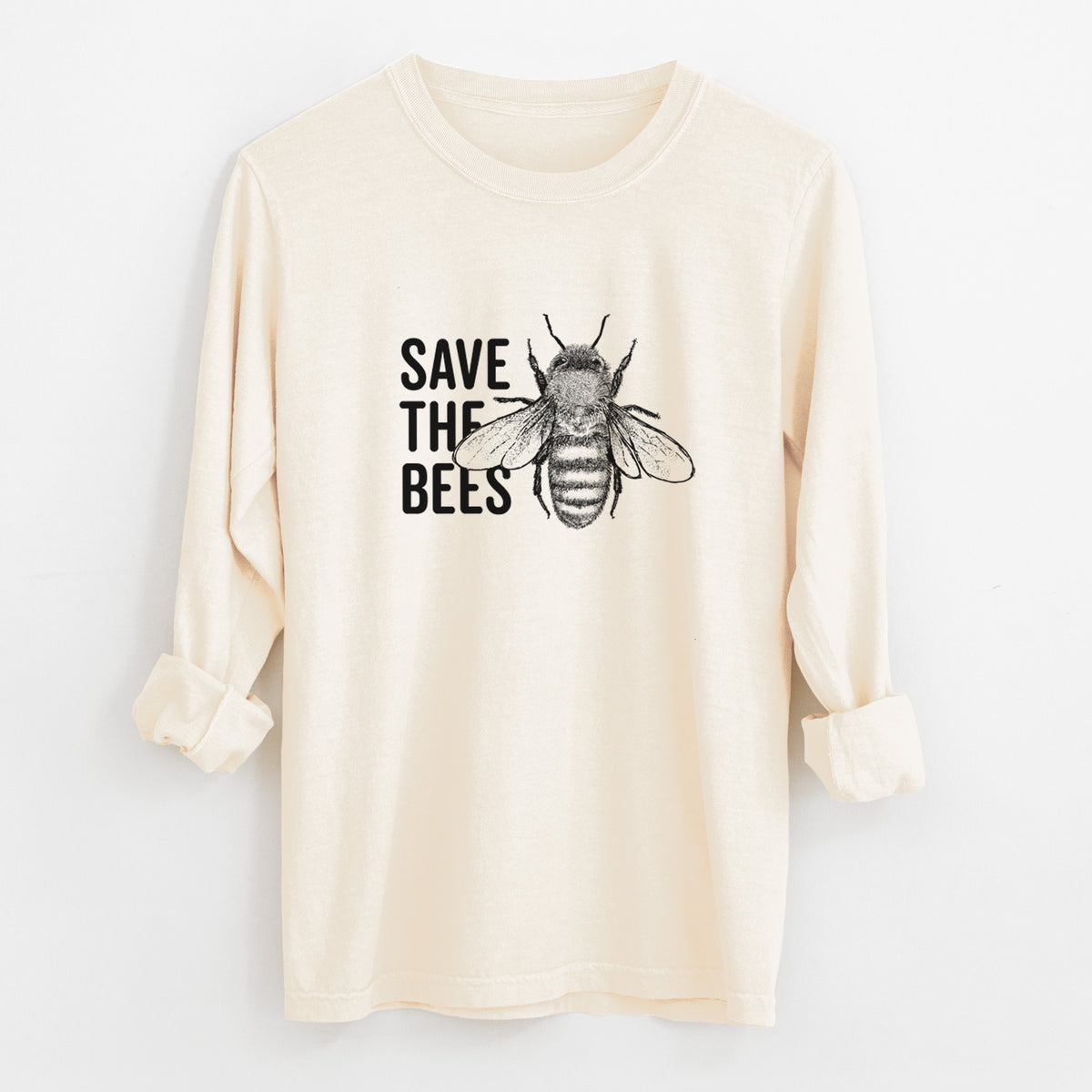 Ivory Comfort Colors long sleeve shirt laid flat with the cuffs rolled, printed with bold black words reading Save the Bees beside a detailed honey bee illustration.